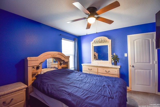 carpeted bedroom with a textured ceiling and ceiling fan