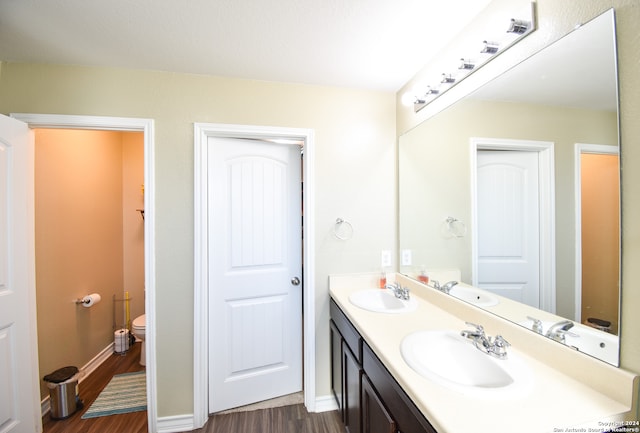 bathroom featuring vanity, toilet, and hardwood / wood-style floors