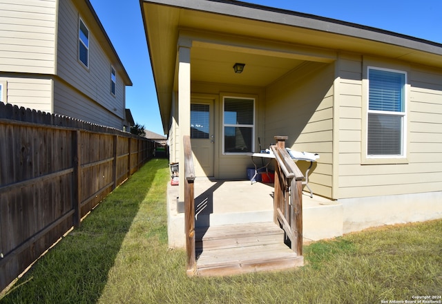 property entrance featuring a patio area and a lawn