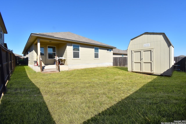 rear view of house with a shed, a patio, and a yard