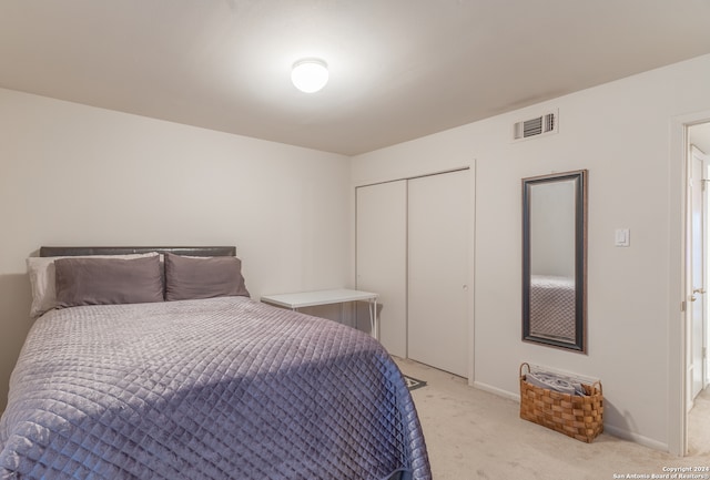 bedroom with light carpet and a closet