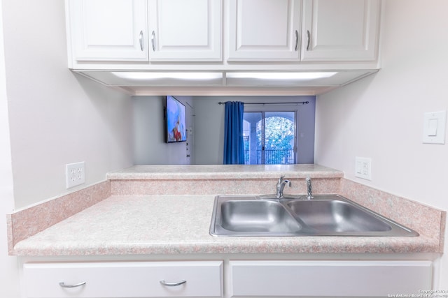 8702 Village Dr Unit 507, San Antonio, TX 78217 - kitchen featuring a sink, light countertops, and white cabinets