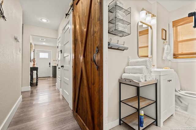 hallway featuring light hardwood / wood-style flooring and a barn door