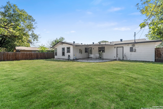 rear view of house with a patio and a lawn