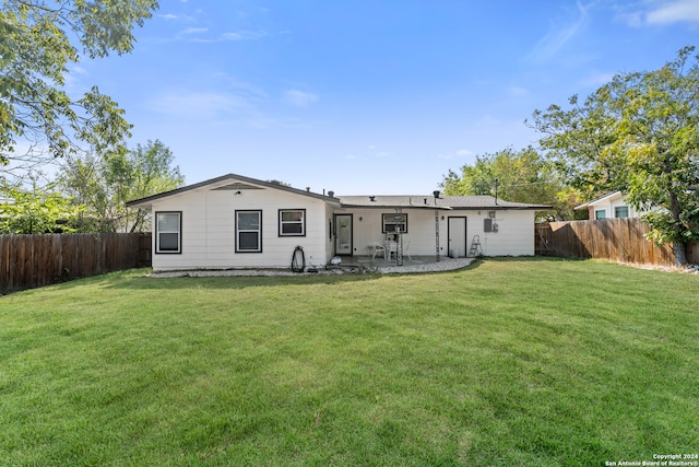 back of house featuring a patio and a yard