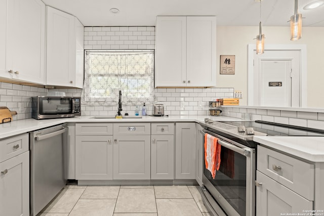 kitchen with sink, appliances with stainless steel finishes, decorative backsplash, and light tile patterned floors