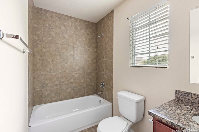 full bathroom with toilet, tiled shower / bath combo, vanity, and a textured ceiling