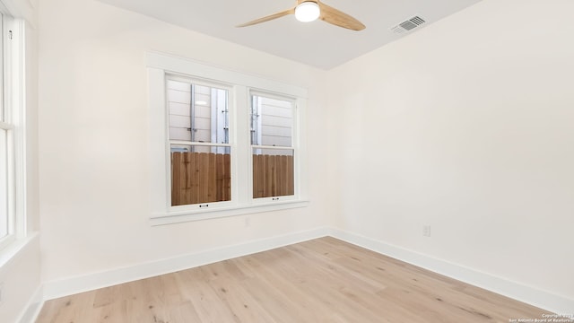 spare room featuring light hardwood / wood-style flooring, ceiling fan, and a wealth of natural light