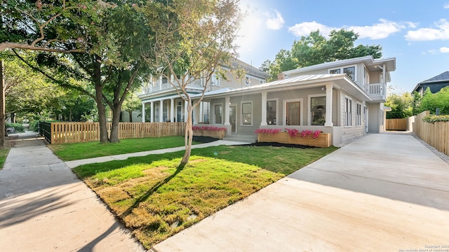 view of front of home with a balcony and a front lawn