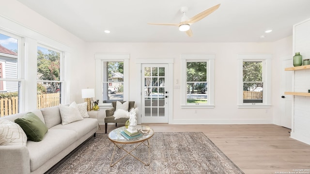 living room with light hardwood / wood-style floors and ceiling fan