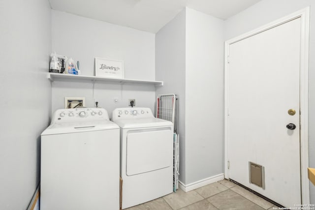 laundry room featuring light tile patterned floors and separate washer and dryer