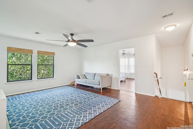 living area featuring ceiling fan and dark hardwood / wood-style floors