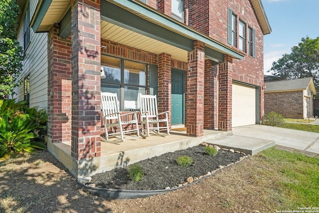 doorway to property with a garage and a porch