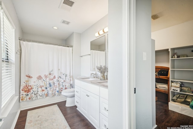 full bathroom with vanity, toilet, hardwood / wood-style flooring, and shower / bath combination with curtain