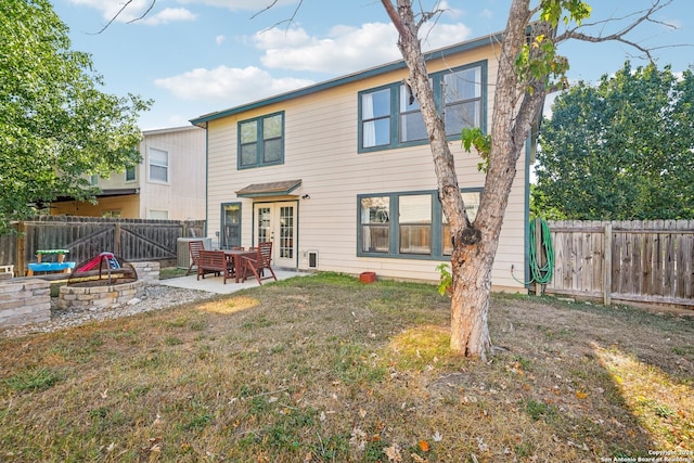 view of front of house with a patio, a front yard, french doors, and a fire pit