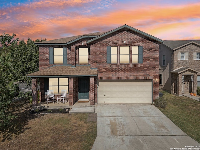 view of front of house featuring a yard, a garage, and a porch