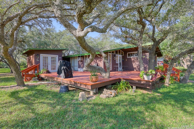 rear view of house featuring a wooden deck and a yard