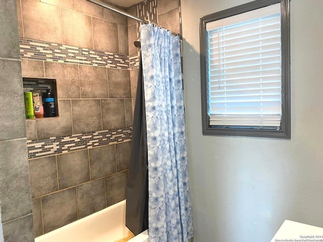 bathroom with a wealth of natural light and shower / tub combo with curtain