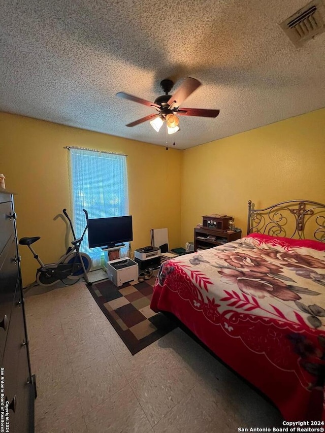 bedroom with a textured ceiling and ceiling fan