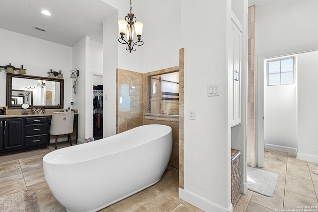 bathroom featuring vanity, an inviting chandelier, a bathing tub, and tile patterned flooring