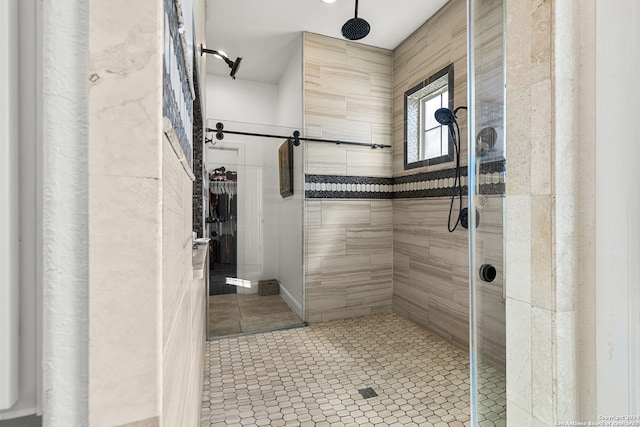 bathroom with tile patterned flooring and tiled shower