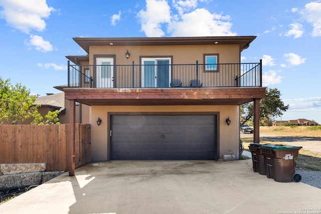 back of property with a balcony and a garage