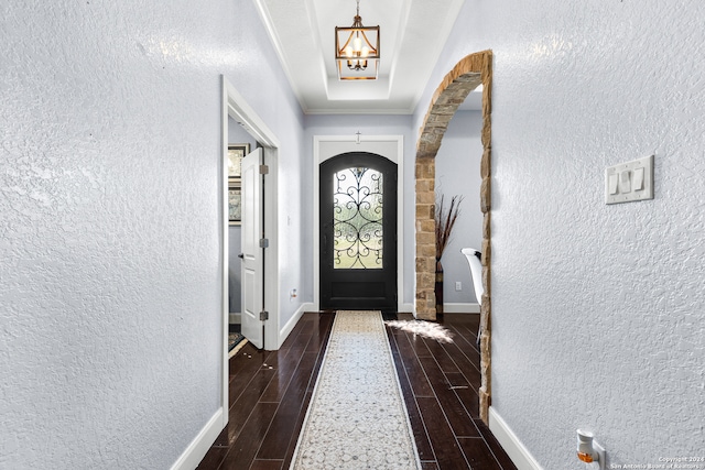 entryway featuring dark wood-type flooring and a chandelier