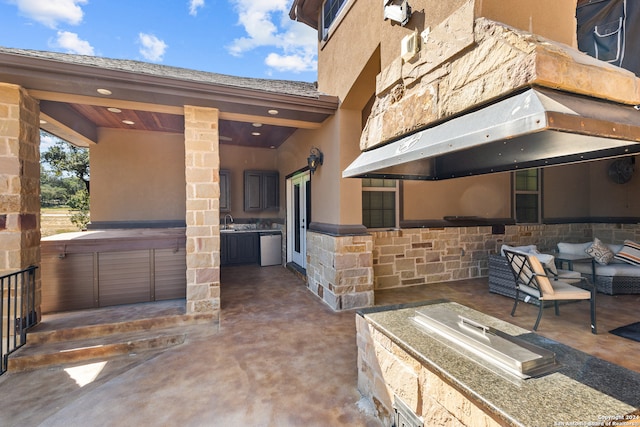 view of patio / terrace with a hot tub, area for grilling, and sink