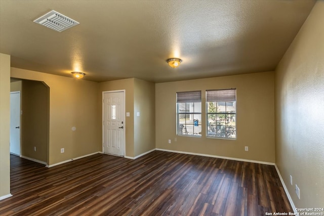 interior space featuring a textured ceiling and dark hardwood / wood-style floors