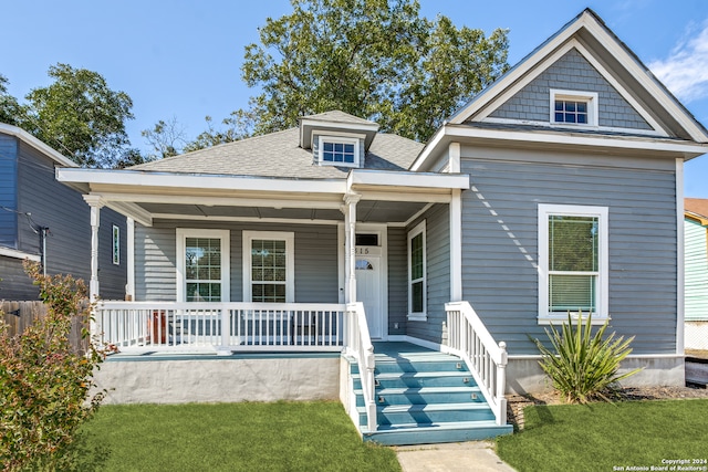 view of front of house with covered porch and a front yard