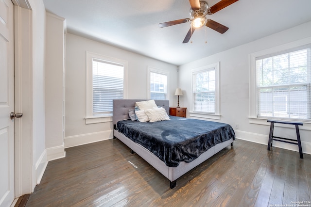 bedroom with dark hardwood / wood-style flooring and ceiling fan