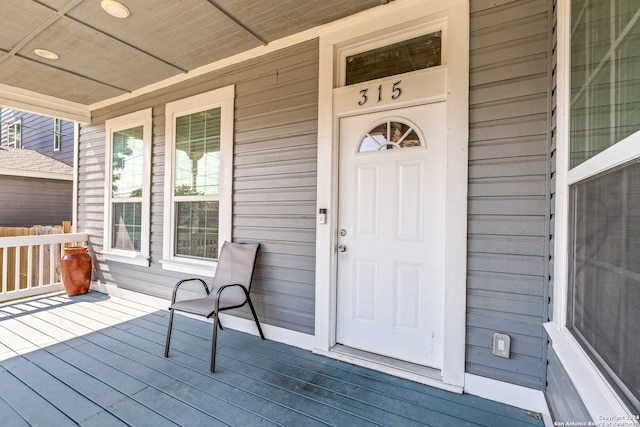 view of exterior entry featuring covered porch