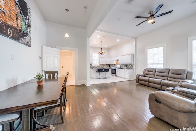 living room with dark hardwood / wood-style floors and ceiling fan with notable chandelier