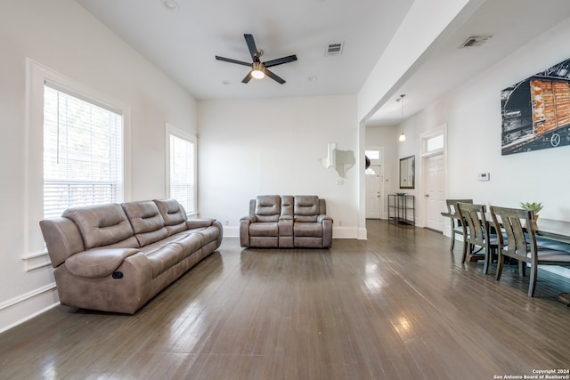 living room with ceiling fan and dark hardwood / wood-style flooring