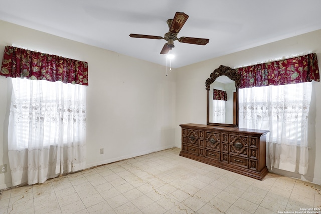 spare room featuring ceiling fan and a wealth of natural light