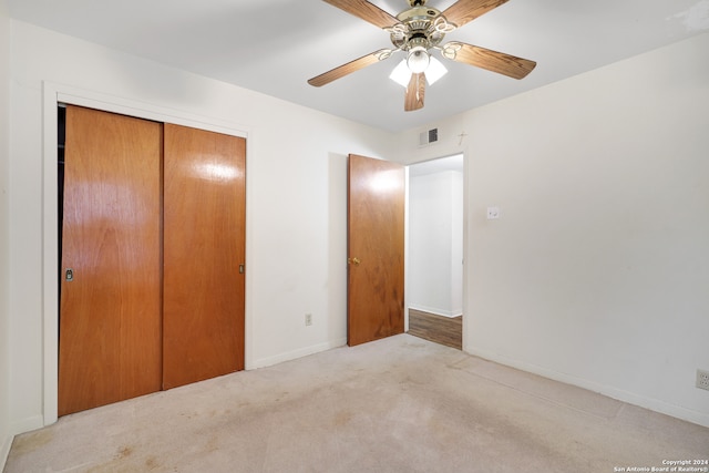 unfurnished bedroom featuring a closet, ceiling fan, and light carpet