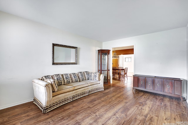 living room with an inviting chandelier and dark hardwood / wood-style flooring