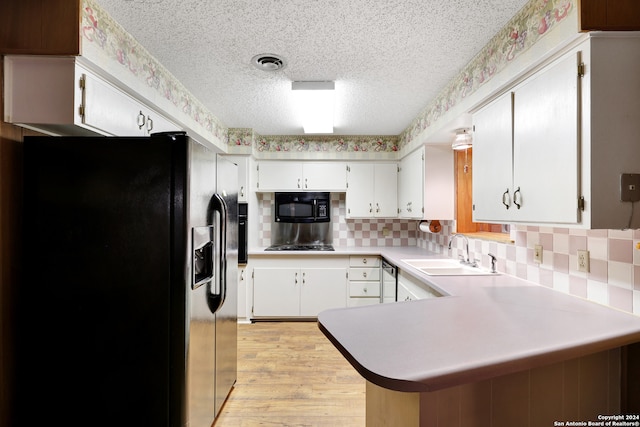 kitchen featuring kitchen peninsula, white cabinetry, black appliances, light hardwood / wood-style floors, and sink