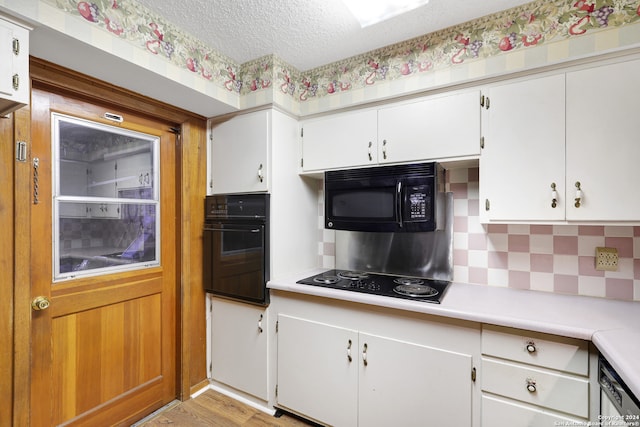 kitchen featuring white cabinets, black appliances, and light wood-type flooring