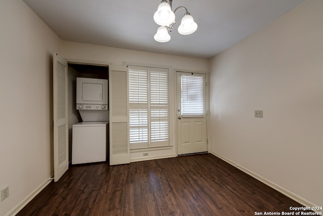 interior space with stacked washer / dryer, an inviting chandelier, and dark hardwood / wood-style floors