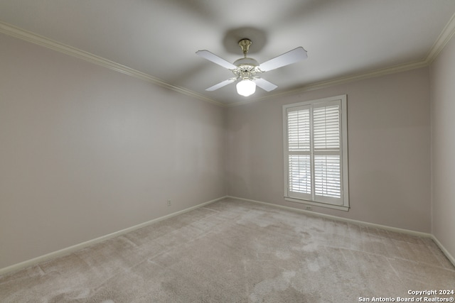 empty room with ornamental molding, light colored carpet, and ceiling fan