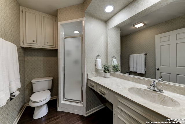 bathroom featuring toilet, an enclosed shower, hardwood / wood-style floors, and vanity