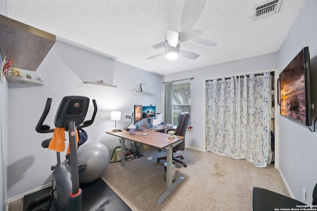 carpeted home office with ceiling fan and a textured ceiling