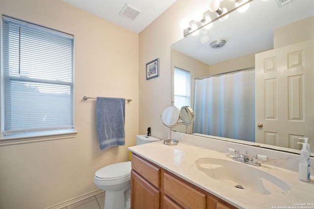 bathroom with toilet, a textured ceiling, vanity, and tile patterned flooring