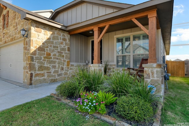 view of exterior entry featuring a porch and a garage