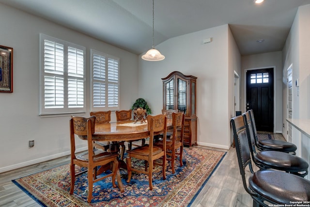 dining room featuring hardwood / wood-style floors and lofted ceiling