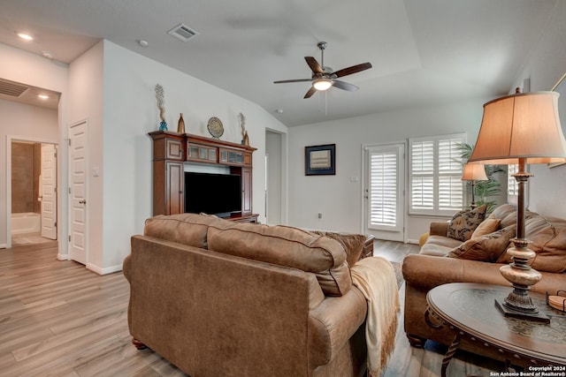 living room featuring light hardwood / wood-style floors, vaulted ceiling, and ceiling fan