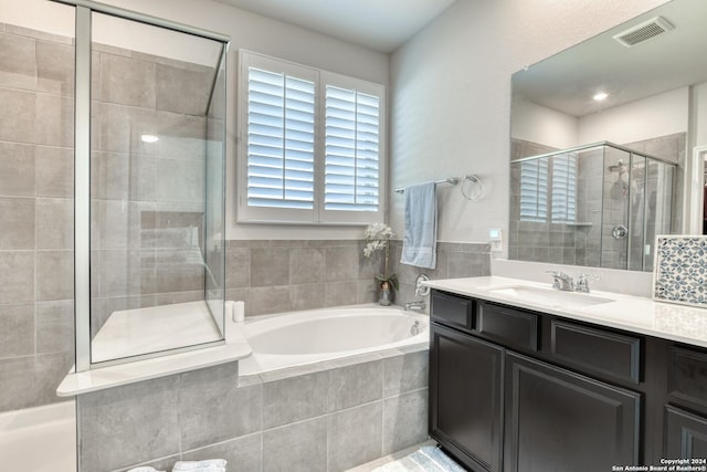 bathroom with vanity and independent shower and bath