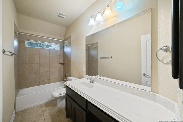 full bathroom with toilet, tiled shower / bath, vanity, and tile patterned floors