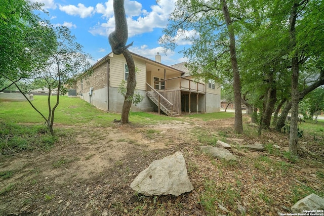 rear view of property with a wooden deck and a yard